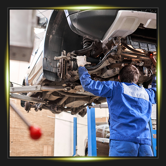 Car mechanic inspecting car steering rod and repair suspension detail. Lifted automobile at repair service station. replacement of ferrule and leverage